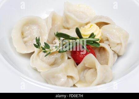 Dumplings with butter - russian pelmeni - italian ravioli - on white plate Stock Photo