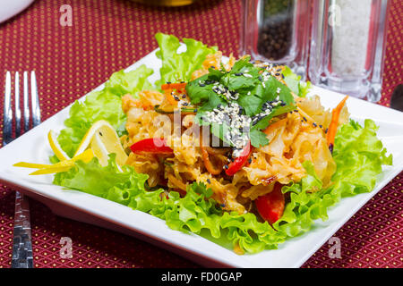 Coleslaw, green leaf lettuce and sesame seeds, selective focus. Table setting. Creative cuisine. Stock Photo