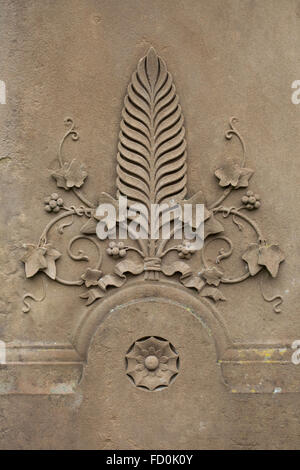 Palm leaf surrounded by ivy. Detail of a tombstone in the churchyard in Creglingen, Baden-Wurttemberg, Germany. Stock Photo