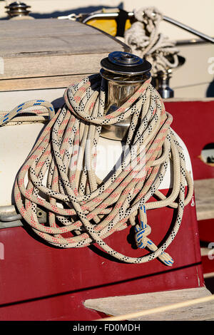 Fragmentary view details of knots and ropes on the yacht moored in the dock.  Oarlock and rope on a sailboat. Stock Photo