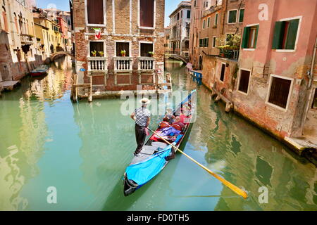 Gondolier with his gondola in one of the numerous canals Venice, Veneto, Italy, UNESCO