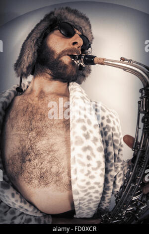 Bearded hipster plays jazz saxophone in leopard print bathrobe taken with fisheye lens Stock Photo