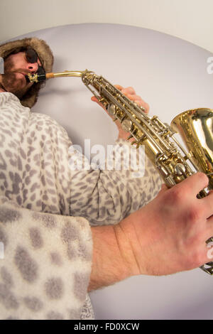 Bearded hipster plays jazz saxophone in leopard print bathrobe taken with fisheye lens Stock Photo