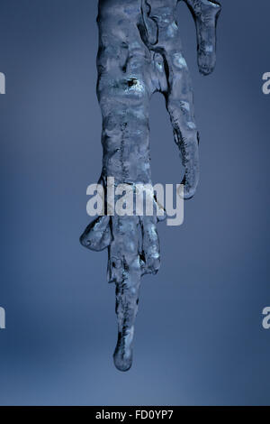 Icicles suspended over a light background with interesting shapes and textures Stock Photo