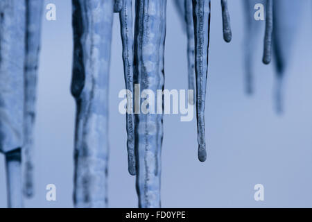 Icicles suspended over a light background with interesting shapes and textures Stock Photo