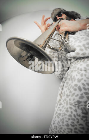 Bearded hipster plays jazz trumpet in leopard print bathrobe taken with fisheye lens Stock Photo