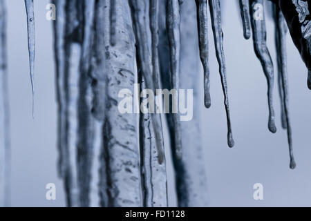 Icicles suspended over a light background with interesting shapes and textures Stock Photo