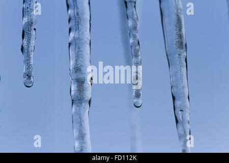 Icicles suspended over a light background with interesting shapes and textures Stock Photo