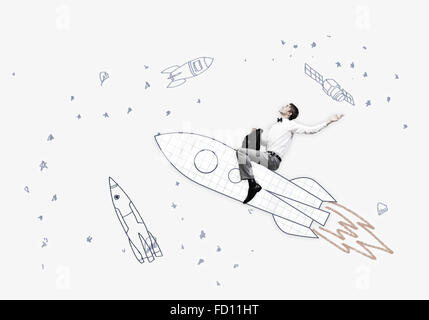 Young businessman flying in sky on drawn rocket Stock Photo