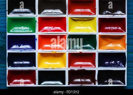 Watercolor paints on a wooden blue surface. Stock Photo