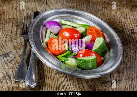 Fresh vegetables in a silver flatware on old wooden table. Selective focus Stock Photo