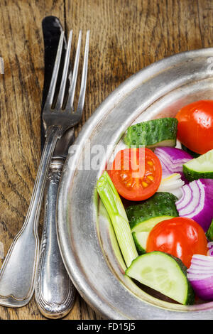 Fresh vegetables in a silver flatware on old wooden table. Selective focus Stock Photo