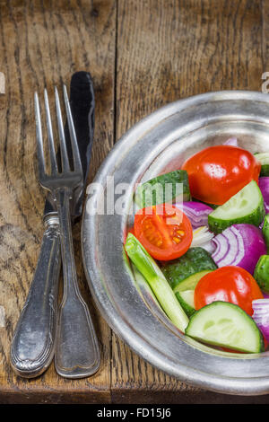 Fresh vegetables in a silver flatware on old wooden table. Selective focus Stock Photo