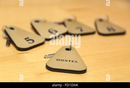The keys of several rooms of a hostel are on a wooden table. Selective focus. Stock Photo