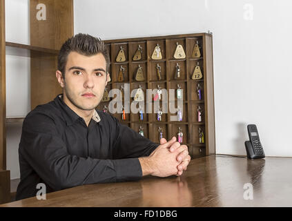 Portrait of a young receptionist at his desk. Stock Photo