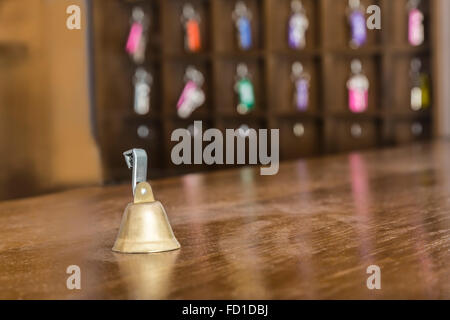 Vintage bell on a hotel reception desk. Extremely selective focus on the bell. Stock Photo