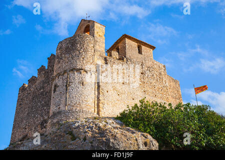 Medieval stone castle and flag of Catalonia on the rock in Spain. Main landmark of Calafell town Stock Photo