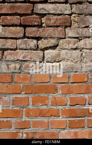 wall made in half from new bricks and other half from old bricks Stock Photo