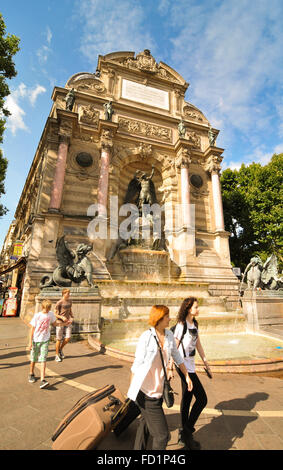 Paris, France - July 7, 2015: Tourists pass by the Fountain Saint Michel in Paris , France Stock Photo