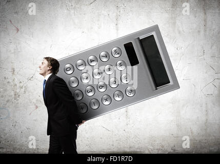 Young businessman carrying huge calculator in hands Stock Photo