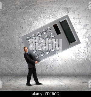 Young businessman carrying huge calculator in hands Stock Photo