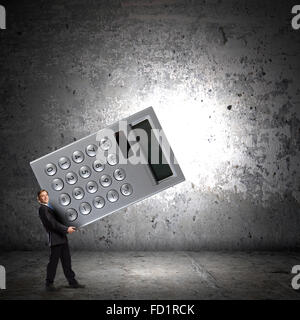 Young businessman carrying huge calculator in hands Stock Photo