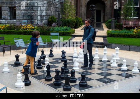 A father playing with his son a giant chess in the Dutch city of Amsterdam Stock Photo