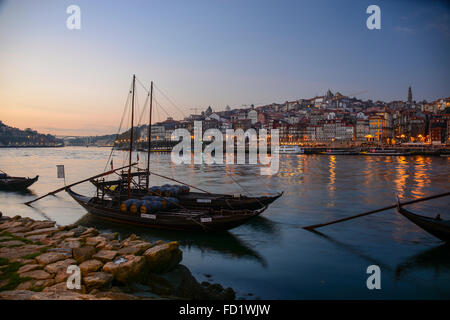 Rabelo boats carrying barrels of port wine on the Douro River, Porto, Portugal – looking across the river to Porto from Gaia Stock Photo