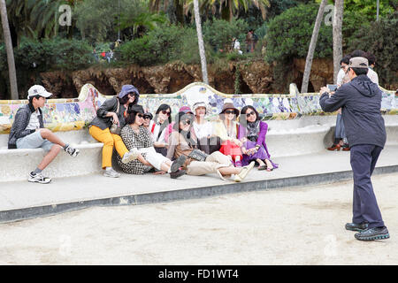 Group photo of oriental visitors to Parc Guell, Barcelona. A designated World Heritage Site and major tourist attraction. Stock Photo