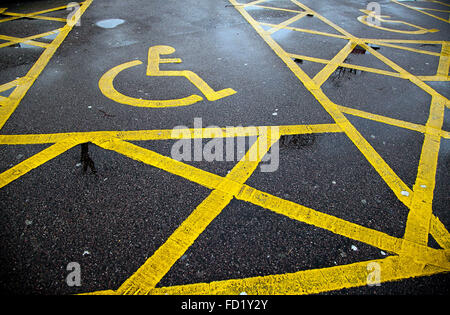 Painted icon of yellow wheelchair in a disable parking bay Stock Photo