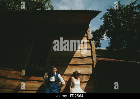 beautiful young wedding couple stands near house Stock Photo