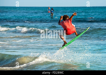 Horizontal portrait of a skim boarder surfing a wave in Cape Verde. Stock Photo