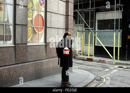 Man talking on his mobile phone on a street near Mansion House, London Stock Photo