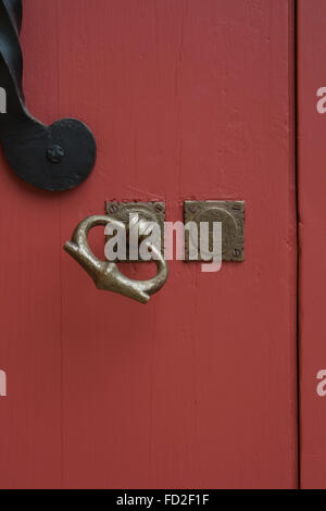 Closeup of painted red door with brass handle Stock Photo
