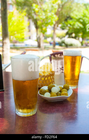 Two glasses of beer and green olives in a summer terrace. Madrid, Spain. Stock Photo