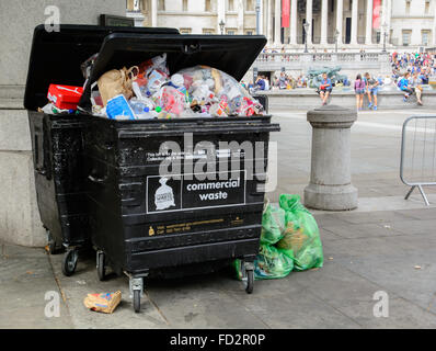 Overflowing commercial waste container full with garbage on Trafalgar Square, London Stock Photo