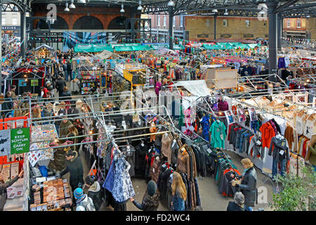 Looking down people shopping at stalls in the The Old historical Spitalfields covered market in London Borough of Tower Hamlets England UK Stock Photo