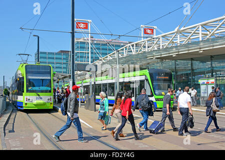 Street scene people on pedestrian crossing over tram tracks at East Croydon British Rail interchange train station tramlink service waiting England UK Stock Photo