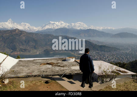 Man going down steps in front of Pokhara and Machapuchare, Nepal Stock Photo