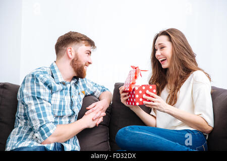 Portrait of a young man giving gift box to his happy girlfriend Stock Photo