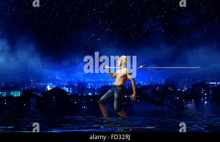 Young boy at night with fishing rod Stock Photo