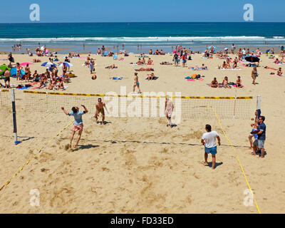 Youngs mens playing volleyball in the Zurriola beach, San Sebastian, Guipuzcoa Stock Photo