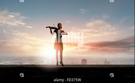 Silhouette of woman playing violin at sunrise Stock Photo - Alamy