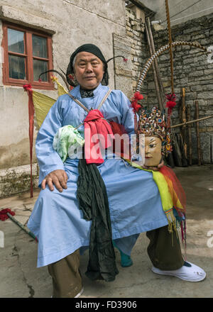 Unmasked Old Han Ground Opera performer resting in courtyard, Liuguan Old Han Village, Guizhou Province, China Stock Photo