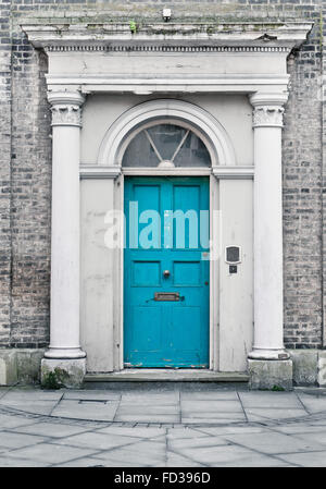 A blue wooden front door in a town house