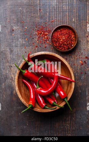 Red Hot Chili Peppers in wooden bowl on dark wooden background Stock Photo