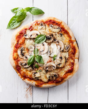 Pizza with mushrooms and basil on white wooden background Stock Photo