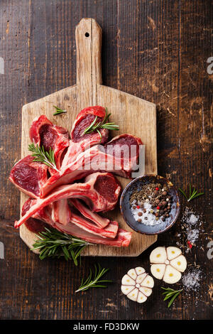 Raw fresh Lamb Meat ribs and seasonings on dark wooden background Stock Photo