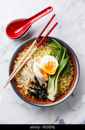 Ramen Asian noodles with egg, enoki and pak choi cabbage on white marble background Stock Photo