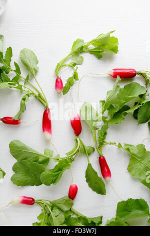 radish roots on white wooden surface, food top view